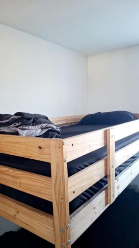a wooden bunk bed in a room at Normandie Vibes Hostel in Los Angeles
