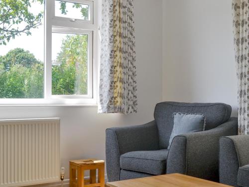 a living room with a chair and a window at Cherry Garth in Goathland