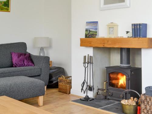 a living room with a fireplace and a couch at Cherry Garth in Goathland