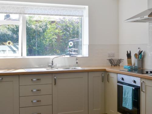 a kitchen with a sink and a window at Cherry Garth in Goathland