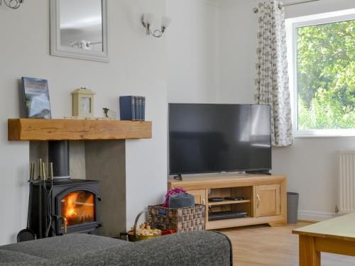 a living room with a fireplace and a television at Cherry Garth in Goathland