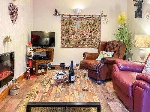 a living room with a couch and a table at Mystified Bungalow in West Burton