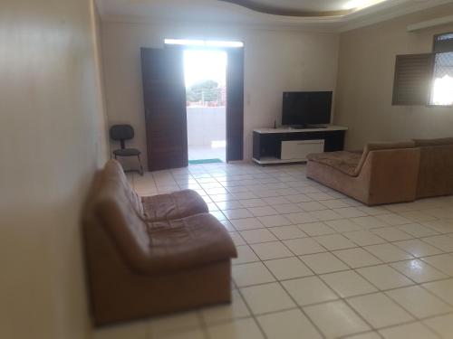 a living room with two couches and a tv at Melos hospedagem jp in João Pessoa