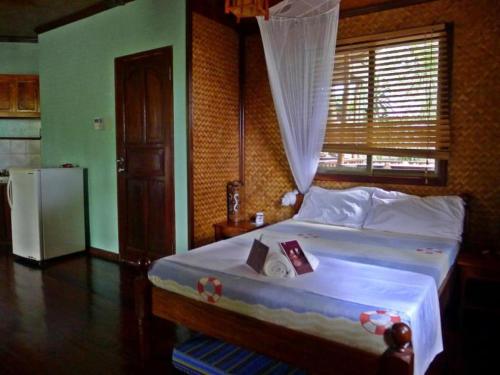 una camera da letto con un letto e un frigorifero di La Salangane Caalan Beach Villa a El Nido