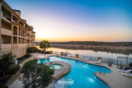 a large swimming pool next to a river at Stylish Island Villa on Lake Travis in Lago Vista