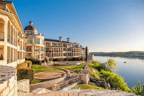 a large building next to a body of water at Stylish Island Villa on Lake Travis in Lago Vista