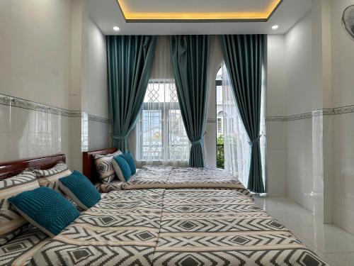 two beds in a room with a window at Căn Hộ 3 PN Rin's House in Phan Thiet