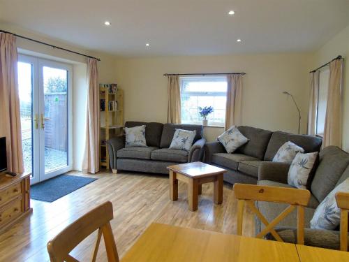 a living room with a couch and a table at Tan Rallt Barn in Tregarth