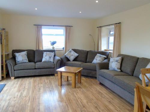 a living room with two couches and a coffee table at Tan Rallt Barn in Tregarth