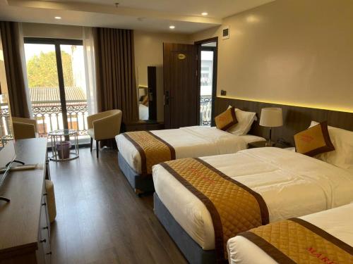 a hotel room with two beds and a balcony at Lạng Sơn Marina Hotel in Lạng Sơn