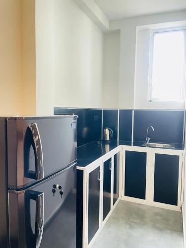 a kitchen with a refrigerator and a sink at Yehara Apartments in Weligama