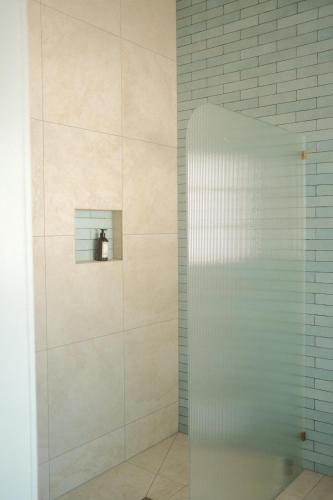 a shower with a glass door in a bathroom at Summer House Magnetic Island in Arcadia