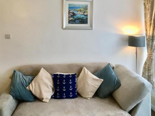 a couch with pillows on it in a living room at The Hollies in Weston-super-Mare