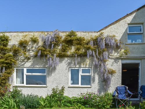 a house with wisteria on the side of it at Thornes Farm Annexe in West Quantoxhead