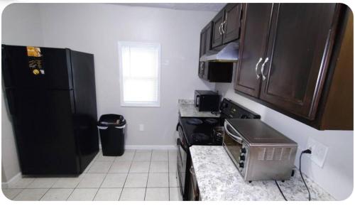a kitchen with a black refrigerator and a microwave at McDaniel House Private Room 7 Shared Bathroom in Atlanta
