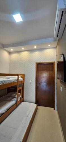 a room with two bunk beds and a door at Loft proximo a orla 02 in Presidente Epitácio