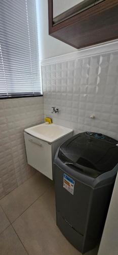 a bathroom with a sink and a trash can at Loft proximo a orla 02 in Presidente Epitácio