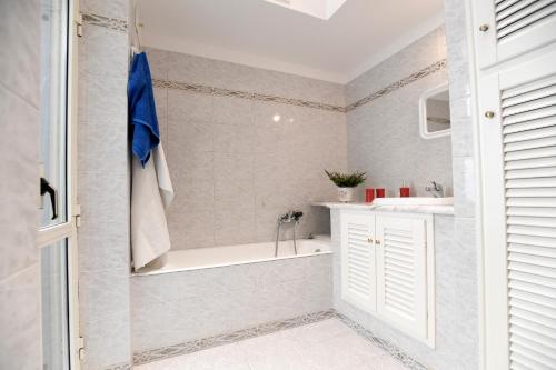 a white bathroom with a tub and a sink at Big House Colosseum in Rome