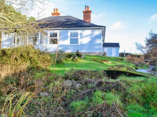 a white house with a grassy yard in front of it at Clarksburn Blue in Monreith