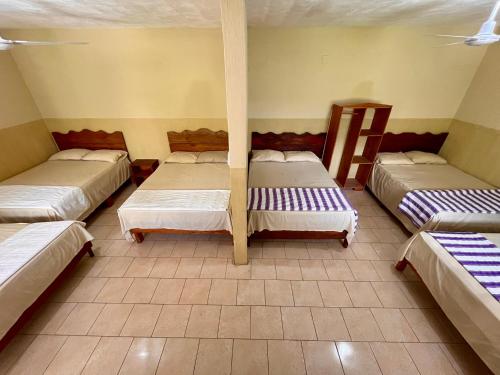 a room with four beds in a room at Hotel Israel in Guastatoya