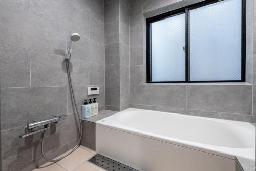 a bathroom with a bath tub and a window at -Numabukuro House- 10-minute walk from Numabukuro station in Tokyo