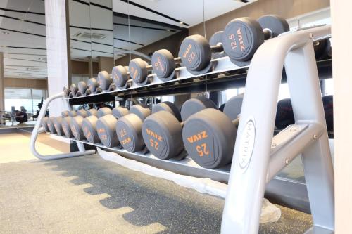 a row of dumbbells on a rack in a gym at SKYVIEW Hotel Bangkok - Sukhumvit in Bangkok