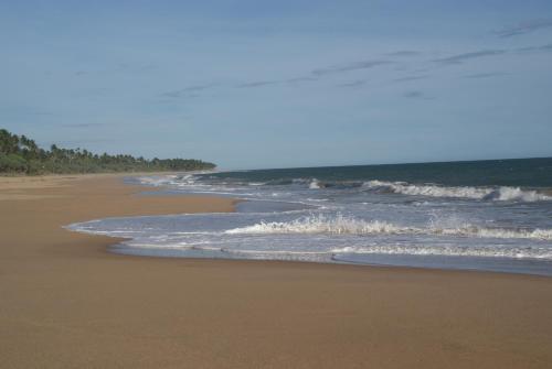 an empty beach with waves crashing on the shore at Lanka Beach Boutique Bungalows & Grand Villa in Tangalle