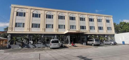 a large building with cars parked in front of it at Townhouse Oak Vera Hotel Near Clark International Airport in Angeles