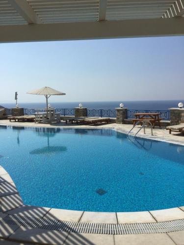 a large swimming pool with a view of the ocean at Hermes-Ios Rooms To Let in Ios Chora