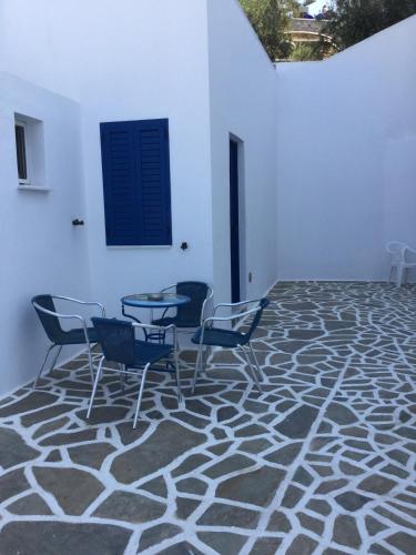 a room with chairs and a table and a wall at Hermes-Ios Rooms To Let in Ios Chora