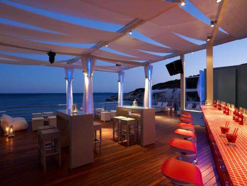 a deck of a cruise ship with tables and chairs at Proteas Blu Resort in Pythagoreio