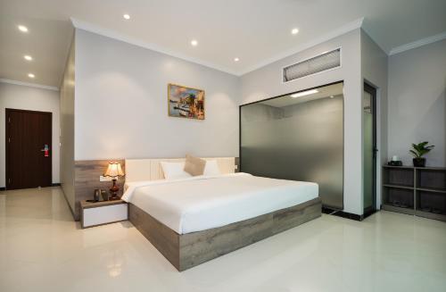 ein Schlafzimmer mit einem großen Bett und einem Spiegel in der Unterkunft Diamond Light Hotel in Hanoi
