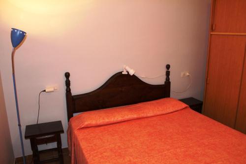 ロザスにあるApartamento Figueres 12のベッドルーム1室(オレンジ色のベッドカバー付)