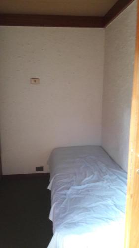 ペスカッセーロリにあるAppartmento I Piniの小さなベッドルーム(青いシーツ付きのベッド1台付)
