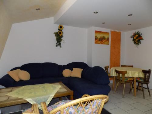a living room with a blue couch and a table at Gästehaus Eschbach in Monschau