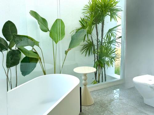 a bathroom with plants on the wall and a tub at MITI TIKAAN villa in Ban Muang Chum