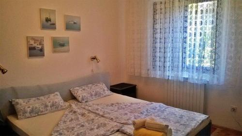 mała sypialnia z łóżkiem i oknem w obiekcie Apartments Zambratija w mieście Zambratija