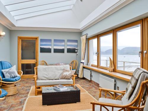 a living room with chairs and a table at Waterside in Tighnabruaich