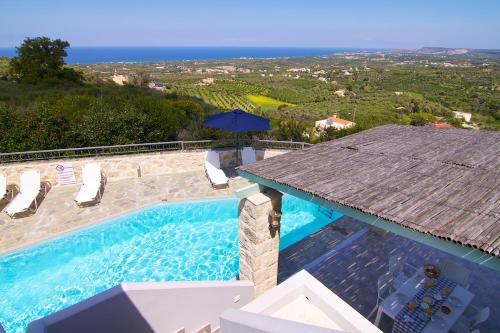 een zwembad met uitzicht op de oceaan bij Villa Ikaros in Agia Triada
