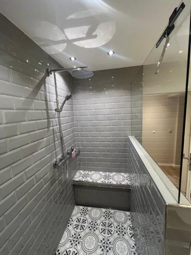 a bathroom with a walk in shower with a tile floor at Saar-Lor-Lux-Perle in Merzig