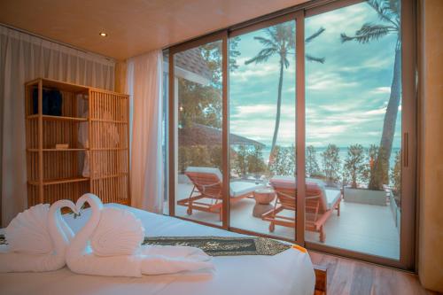 a room with two swans on a bed and a balcony at SeaTara Resort in Ko Phangan