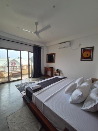 a bedroom with a large bed and a balcony at Sky Bloom Ahangama in Ahangama
