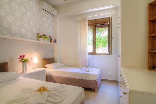Habitación pequeña con 2 camas y ventana en Villa Ikaros en Agia Triada