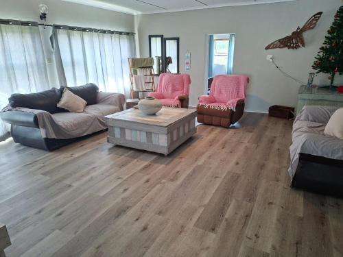 a living room with couches and a christmas tree at Omidraai Opihoek in Boknes