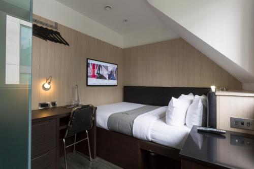 a hotel room with a bed and a desk with a computer at The Z Hotel Victoria in London