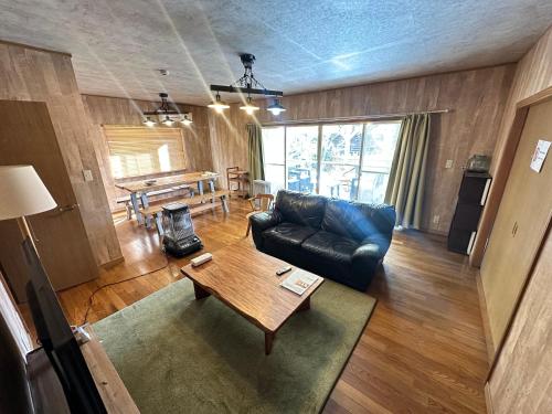 a living room with a couch and a table at 一棟丸ごと貸別荘あそべるごでぃふーぞ in Takamori