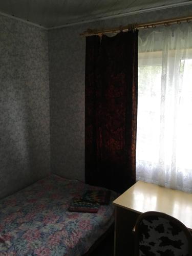 a bedroom with a bed and a desk and a window at Tolli Hostel & Holiday House in Valga
