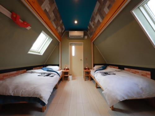 two beds in a room with two windows at Yufuin Onsen 8A1 Yaeichi in Yufu