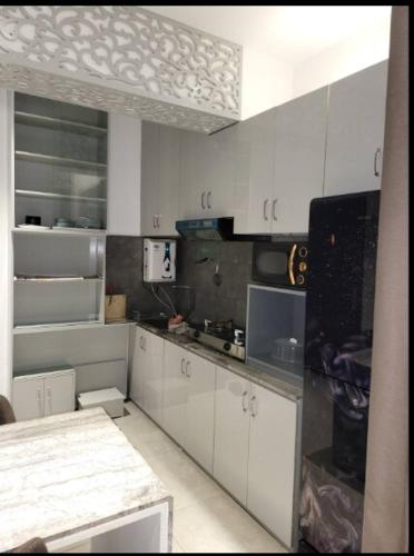 una cucina con mobili bianchi e un piano di lavoro di 1BR Studio with Rooftop Access a Dhaka