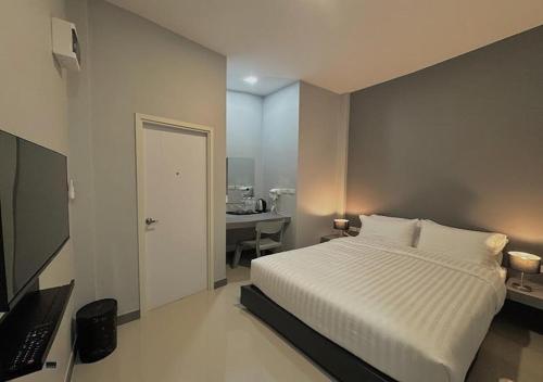 a bedroom with a bed and a desk with a laptop at โรงแรมหลังสวนเพลส Langsuan place Hotel in Lang Suan